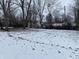 Snowy backyard surrounded by bare trees, offering a serene and private outdoor space at 5834 42Nd St, Indianapolis, IN 46226