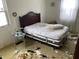 Bedroom with a dark wood headboard, dingy carpet, and visible deferred maintenance at 5834 42Nd St, Indianapolis, IN 46226