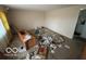 Living room featuring worn carpet, basic walls, and showing substantial deferred maintenance at 5834 42Nd St, Indianapolis, IN 46226