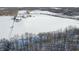 Aerial view of a snow-covered estate with open land, bare trees, and several buildings at 5895 W 265 N, Columbus, IN 47201
