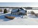 Aerial view of a home with a three-car garage, sunroom, and surrounding snowy grounds at 5895 W 265 N, Columbus, IN 47201