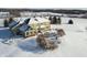 Drone shot of back of house with patio and pergola surrounded by a field of snow in winter at 5895 W 265 N, Columbus, IN 47201