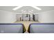 Attic room featuring a black iron railing, wood-look flooring, and two beds with striped blankets at 5895 W 265 N, Columbus, IN 47201