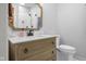 Bathroom featuring a modern vanity with a marble countertop, decorative mirror, and neutral color palette at 5895 W 265 N, Columbus, IN 47201