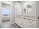 Bathroom featuring custom cabinets, a round mirror, and neutral tile flooring at 5895 W 265 N, Columbus, IN 47201