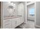 Bathroom featuring custom cabinets, a round mirror, and neutral tile flooring at 5895 W 265 N, Columbus, IN 47201