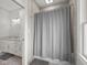 Bright bathroom featuring a tiled shower and vanity with a marble countertop, decorative mirror, and neutral color palette at 5895 W 265 N, Columbus, IN 47201