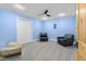 The blue accent bedroom features two black leather chairs, neutral carpeting, and wood-style doors at 5895 W 265 N, Columbus, IN 47201