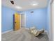 The blue accent bedroom features neutral carpeting, a rocking cradle, and wood-style doors at 5895 W 265 N, Columbus, IN 47201