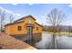 Exterior view of a modern barndominium with brown siding, black trim, and a spacious, reflective driveway at 5895 W 265 N, Columbus, IN 47201