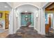 Spacious foyer showcasing slate flooring, arched doorways, and a staircase with wrought iron railings at 5895 W 265 N, Columbus, IN 47201