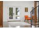 Bright foyer with a pair of orange armchairs, neutral rug, and glass paneled doors with views to the outdoors at 5895 W 265 N, Columbus, IN 47201