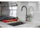 Close up of the kitchen sink with stainless steel faucet, marble countertops, and stainless steel backsplash at 5895 W 265 N, Columbus, IN 47201