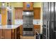 Gourmet kitchen with stainless steel range, custom hood vent, marble countertops, and hardwood floors at 5895 W 265 N, Columbus, IN 47201