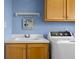 Laundry room with sink, cabinetry, blue walls, decor, and white washer at 5895 W 265 N, Columbus, IN 47201