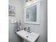 Elegant powder room with a pedestal sink, stylish mirror, and soft lighting at 602 E Beecher St, Indianapolis, IN 46203