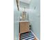 Powder room with modern vanity, decorative mirror, and striped rug at 6428 Bluff Crest Ct, Indianapolis, IN 46217