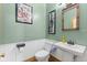Cozy bathroom with a pedestal sink, toilet, and fresh green paint at 6428 Bluff Crest Ct, Indianapolis, IN 46217