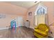 Bright bedroom featuring light pink walls, wood floors, and unique arched window at 6428 Bluff Crest Ct, Indianapolis, IN 46217