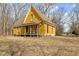 Side view of a yellow two-story house with a covered porch and dry grassy lot at 6428 Bluff Crest Ct, Indianapolis, IN 46217