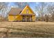 Exterior view of a yellow house with a covered front porch, set on a large dry grassy lot at 6428 Bluff Crest Ct, Indianapolis, IN 46217