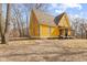 Charming yellow two-story house with a covered porch, set on a dry grassy lot with bare trees at 6428 Bluff Crest Ct, Indianapolis, IN 46217