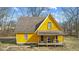 Side exterior view of a yellow two-story house with a covered porch and bare trees at 6428 Bluff Crest Ct, Indianapolis, IN 46217