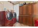 Well-equipped laundry room with a side-by-side washer and dryer, storage cabinet, and utility sink at 6428 Bluff Crest Ct, Indianapolis, IN 46217