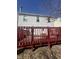A cozy back deck is shown with an entrance to the house and a red painted safety rail at 6817 Everbloom Ln, Indianapolis, IN 46217