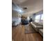 Bright and airy living room with hardwood floors, a ceiling fan, large windows, and an open layout to the kitchen at 6817 Everbloom Ln, Indianapolis, IN 46217