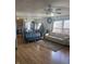 Bright and airy living room with hardwood floors, a ceiling fan, large windows, and an open layout to the kitchen at 6817 Everbloom Ln, Indianapolis, IN 46217