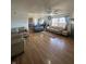 Bright and airy living room with hardwood floors, a ceiling fan, large windows, and a cozy fireplace at 6817 Everbloom Ln, Indianapolis, IN 46217