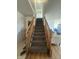 Carpeted staircase with wooden railings, leading to the upper level of the home at 6817 Everbloom Ln, Indianapolis, IN 46217