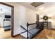 Upstairs hallway featuring wood floors, a banister, and entry to an exercise room at 7089 W 150 N, Greenfield, IN 46140