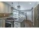 Bright kitchen with a stove top, island, brick backsplash and view into the breakfast nook at 7089 W 150 N, Greenfield, IN 46140