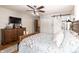 Bedroom features hardwood flooring, a ceiling fan and barn door to bathroom at 7089 W 150 N, Greenfield, IN 46140