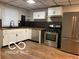 Modern kitchen boasts stainless steel appliances, sleek countertops, and ample cabinetry at 1220 E Second St, Greenfield, IN 46140