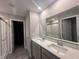 Bathroom featuring double sink vanity with quartz counters and large mirror with shower and glass door at 1256 Turner Trace N Pl, Avon, IN 46123