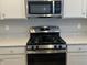 Close-up of modern stainless steel microwave and stove with gray cabinets at 1256 Turner Trace N Pl, Avon, IN 46123
