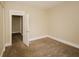 Neutral bedroom featuring tan carpet and a white painted trim and entry door at 1343 Edgemont Ave, Indianapolis, IN 46208