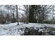 Snow-covered backyard with large bare trees and visible debris on an overcast winter day at 1621 Indiana Ave, Anderson, IN 46012