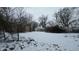 Backyard view showing a snowy lot with two garages in the background at 1621 Indiana Ave, Anderson, IN 46012