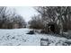 Snowy backyard with an open shed filled with debris on an overcast winter day at 1621 Indiana Ave, Anderson, IN 46012