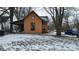 Exterior view of a quaint home with orange siding and red trim in a snowy landscape at 1621 Indiana Ave, Anderson, IN 46012
