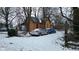 Exterior view of a house with orange siding and bare trees, with a blue and a silver car at 1621 Indiana Ave, Anderson, IN 46012