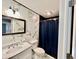 Stylish bathroom featuring a marble-style accent wall, modern vanity, and shower with a black shower curtain at 1820 N Dequincy St, Indianapolis, IN 46218