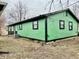 Angle shot of side and rear of green sided house with black trim at 1820 N Dequincy St, Indianapolis, IN 46218