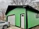Oversized detached garage with a green exterior, white door, and a single-door entrance at 1820 N Dequincy St, Indianapolis, IN 46218