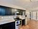 Open-concept kitchen with stainless steel appliances, dark cabinets, and hardwood floors at 1820 N Dequincy St, Indianapolis, IN 46218