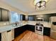 Modern kitchen featuring dark cabinets, stainless steel appliances, and granite countertops, creating an elegant and functional space at 1820 N Dequincy St, Indianapolis, IN 46218